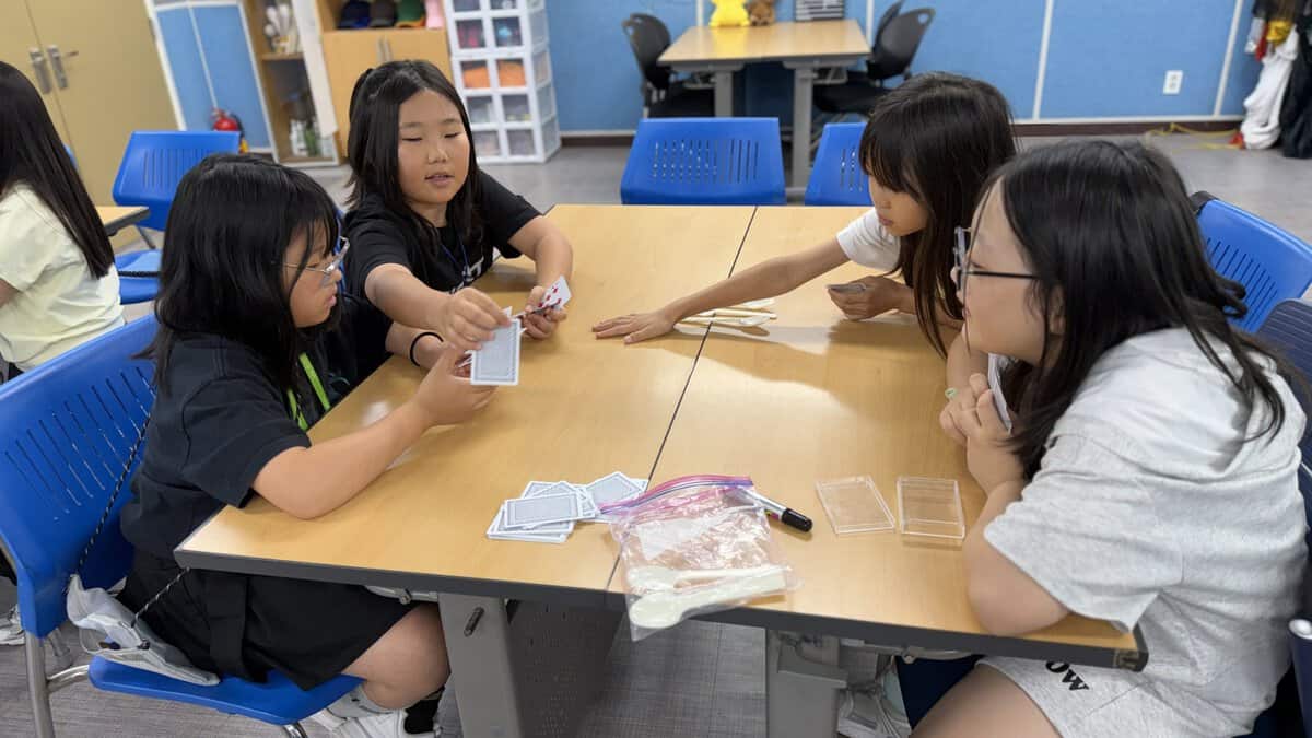 小学生がトランプを使ったSpoonsゲームに取り組む様子