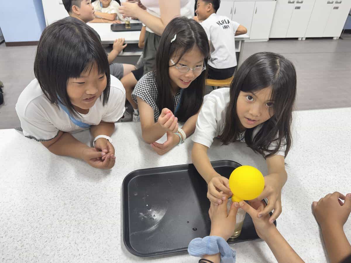 酢と重曹の実験で風船を膨らませる子どもたち