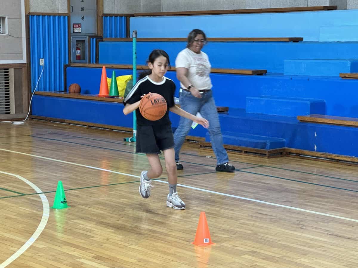体育館でバスケットボールを楽しむ小学生たち