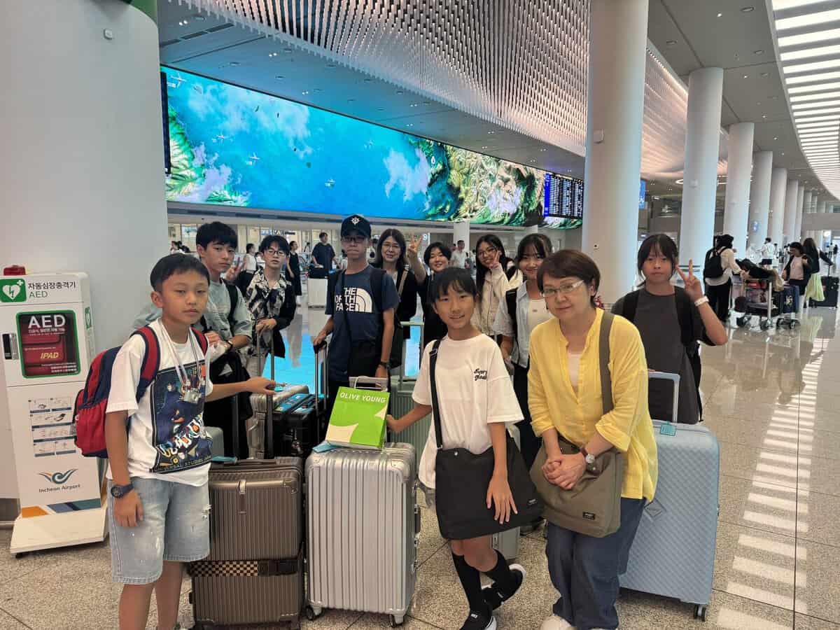 金浦空港に到着してみんなで記念撮影する様子
