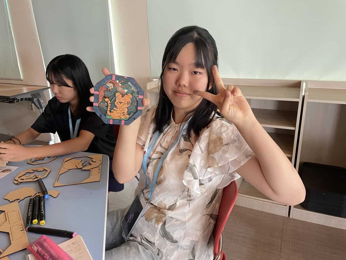Natural Artの授業でトラ柄の木製キットに色を塗る子ども